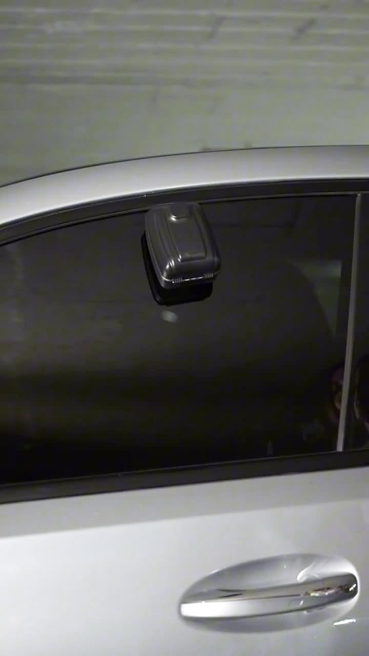 The secure lockbox mounted on a car's window in a residential garage